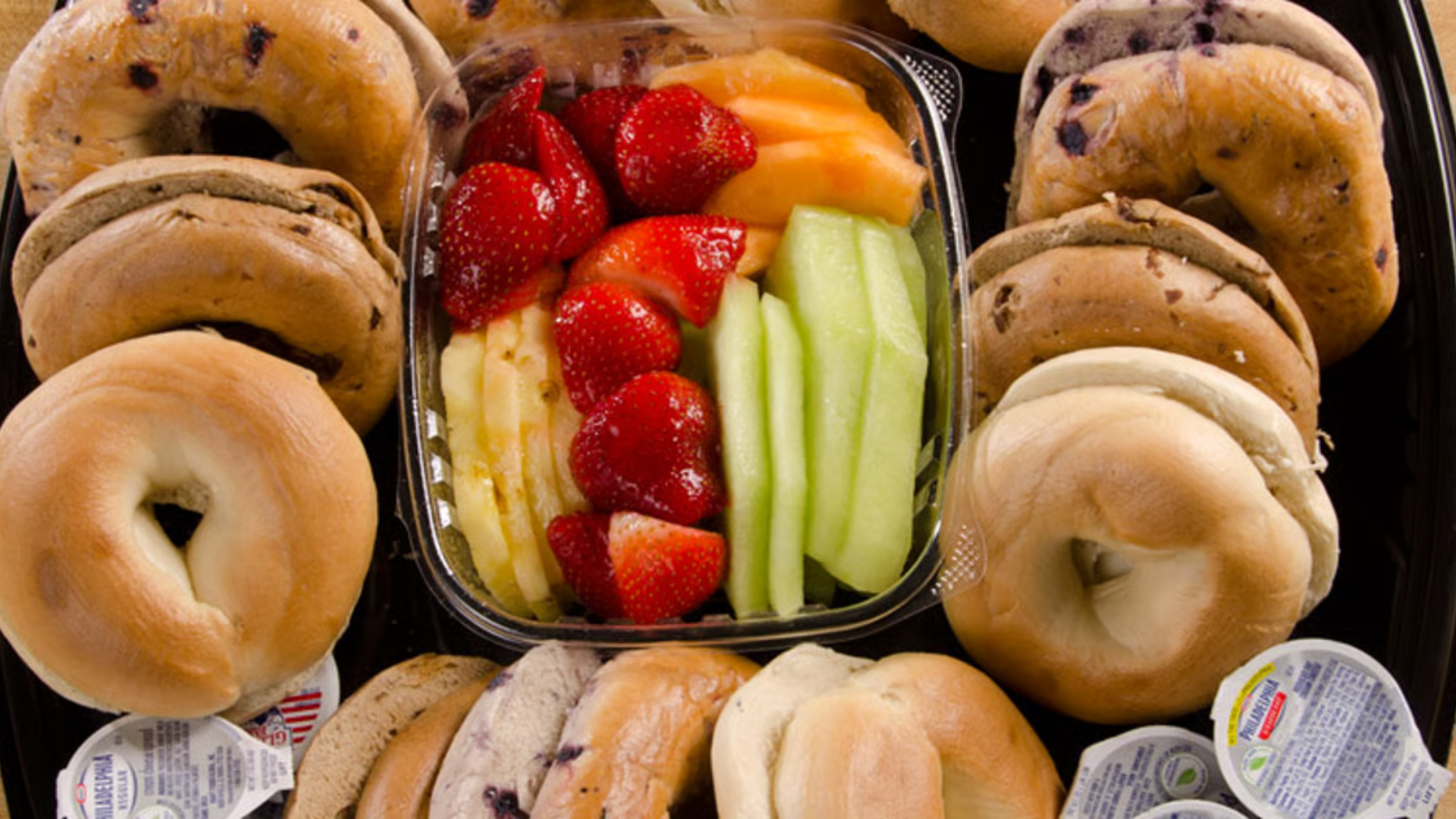 breakfast ideas for work meetings flat lay with coffee bagels and fruit